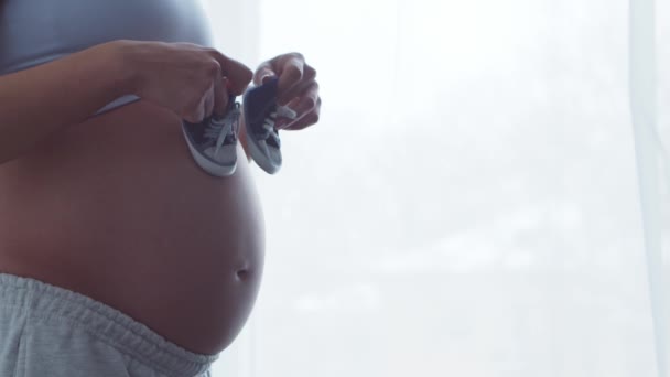 Молодая беременная женщина отдыхает дома и ждет ребенка. Концепция беременности, материнства, здоровья и образа жизни. — стоковое видео