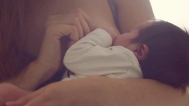 Annem emziren bir bebek emziriyor. Bebeğin ve annesinin yakın plan portresi. Pencere ışığı.