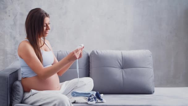 La giovane donna incinta sta riposando a casa e aspetta un bambino. Il concetto di gravidanza, maternità, salute e stile di vita. — Video Stock