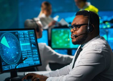 Uçak kontrol subayı kontrol kulesinden gelen uçakları izliyor. Hava hizmetleri ofisi navigasyon sistemleri, radarlar ve bilgisayar istasyonlarıyla donatılmıştır. Havacılık kavramı.