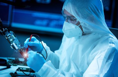 Bilim adamı mikro elektronik ve işlemcilerin araştırılması ve geliştirilmesi için modern bir bilim laboratuvarında çalışıyor. Mikroişlemci imalat işçisi bilgisayar teknolojisi ve ekipmanı kullanıyor.