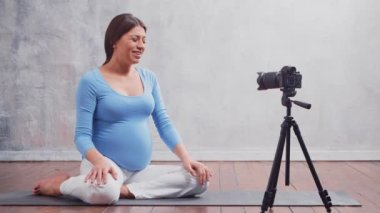 Genç hamile bir kadın hamilelikle ilgili bir video bloğu hazırlıyor. Etkilenen kişi bir kameraya video veya akış kaydeder.