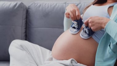 Genç hamile kadın evde dinleniyor ve bebek bekliyor. Hamilelik, annelik, sağlık ve yaşam tarzı kavramı.