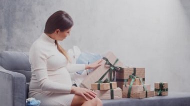 Genç hamile kadın evde dinleniyor ve bebek bekliyor. Hamilelik, annelik, sağlık ve yaşam tarzı kavramı.