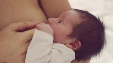 Annem emziren bir bebek emziriyor. Bebeğin ve annesinin yakın plan portresi. Pencere ışığı.