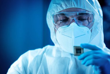 Bilim adamı mikro elektronik ve işlemcilerin araştırılması ve geliştirilmesi için modern bir bilim laboratuvarında çalışıyor. Mikroişlemci imalat işçisi bilgisayar teknolojisi ve ekipmanı kullanıyor.