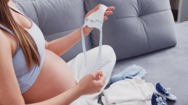 Genç hamile kadın evde dinleniyor ve bebek bekliyor. Hamilelik, annelik, sağlık ve yaşam tarzı kavramı.