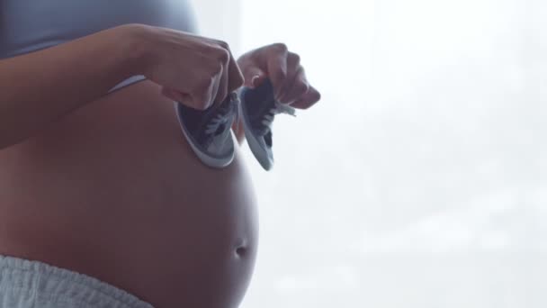A fiatal terhes nő otthon pihen és gyereket vár. A terhesség, az anyaság, az egészség és az életmód fogalma. — Stock videók