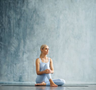 Spor giyimli genç, narin sarışın kadın geniş bir eğitim odasında fitness yapıyor. Spor, sağlık, jimnastik ve yaşam tarzı konsepti.