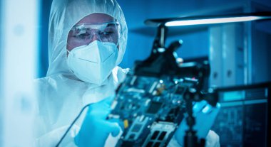 Bilim adamı mikro elektronik ve işlemcilerin araştırılması ve geliştirilmesi için modern bir bilim laboratuvarında çalışıyor. Mikroişlemci imalat işçisi bilgisayar teknolojisi ve ekipmanı kullanıyor.