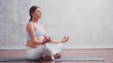 Genç hamile kadın yoga yapıyor ve evde meditasyon yapıyor. Sağlık, farkındalık, rahatlama ve sağIık kavramı.