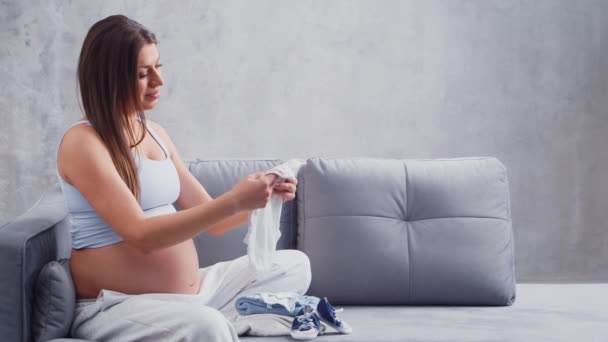 La giovane donna incinta sta riposando a casa e aspetta un bambino. Il concetto di gravidanza, maternità, salute e stile di vita. — Video Stock