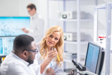 Profesyonel bilim adamları modern bir bilimsel araştırma laboratuvarında bir aşı üzerinde çalışıyorlar. Genetik mühendisliği işyeri. Gelecekteki teknoloji ve bilim.