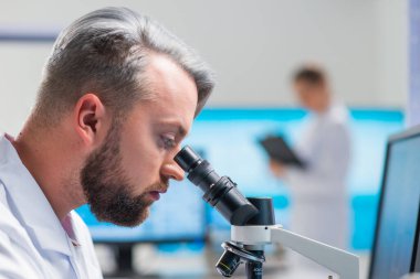 Profesyonel bilim adamları modern bir bilimsel araştırma laboratuvarında bir aşı üzerinde çalışıyorlar. Genetik mühendisliği işyeri. Gelecekteki teknoloji ve bilim.