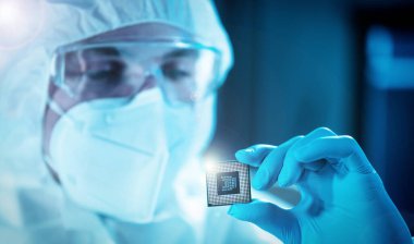 Bilim adamı mikro elektronik ve işlemcilerin araştırılması ve geliştirilmesi için modern bir bilim laboratuvarında çalışıyor. Mikroişlemci imalat işçisi bilgisayar teknolojisi ve ekipmanı kullanıyor.