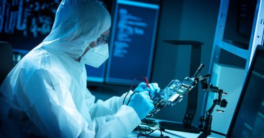 Bilim adamı mikro elektronik ve işlemcilerin araştırılması ve geliştirilmesi için modern bir bilim laboratuvarında çalışıyor. Mikroişlemci imalat işçisi bilgisayar teknolojisi ve ekipmanı kullanıyor.