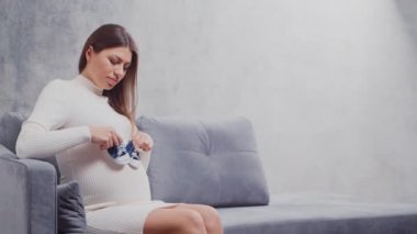 Genç hamile kadın evde dinleniyor ve bebek bekliyor. Hamilelik, annelik, sağlık ve yaşam tarzı kavramı.