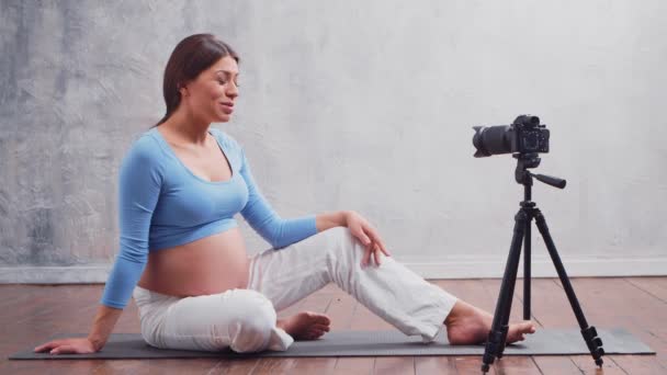 Una mujer embarazada joven hace un vlog sobre el embarazo. El influencer graba videos o transmisiones en una cámara. — Vídeos de Stock