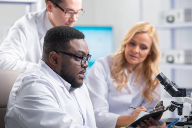 Profesyonel bilim adamları modern bir bilimsel araştırma laboratuvarında bir aşı üzerinde çalışıyorlar. Genetik mühendisliği işyeri. Gelecekteki teknoloji ve bilim.