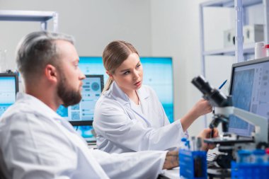 Profesyonel bilim adamları modern bir bilimsel araştırma laboratuvarında bir aşı üzerinde çalışıyorlar. Genetik mühendisliği işyeri. Gelecekteki teknoloji ve bilim.