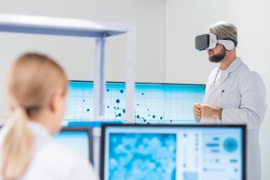 Genetik mühendisleri Sanal Gerçeklik teknolojisini kullanıyorlar. Profesyonel bilim adamları modern bir bilimsel araştırma laboratuvarında bir aşı üzerinde çalışıyorlar. Geleceğin bilimi.