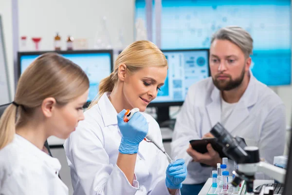A tudósok profi csapata egy vakcinán dolgozik egy modern tudományos kutató laboratóriumban. Genetikai mérnöki munkahely. Jövőbeli technológia és tudomány. Stock Fotó