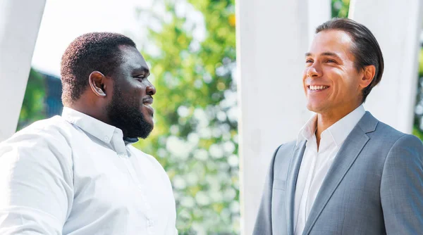 Financieel, zakelijk en samenwerkingsconcept. Twee succesvolle zakenmannen praten op straat. Kantoormedewerkers discussiëren over zakelijke kwesties buiten. — Stockfoto