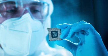 Bilim adamı mikro elektronik ve işlemcilerin araştırılması ve geliştirilmesi için modern bir bilim laboratuvarında çalışıyor. Mikroişlemci imalat işçisi bilgisayar teknolojisi ve ekipmanı kullanıyor.