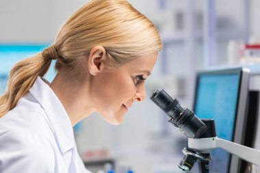 Profesyonel kadın bilim adamı modern bir bilimsel araştırma laboratuvarında aşı üzerinde çalışıyor. Genetik mühendisliği işyeri. Gelecekteki teknoloji ve bilim.