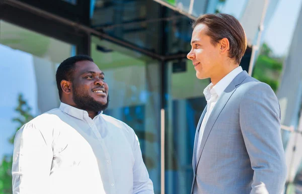 Financieel, zakelijk en samenwerkingsconcept. Twee succesvolle zakenmannen praten op straat. Kantoormedewerkers discussiëren over zakelijke kwesties buiten. — Stockfoto