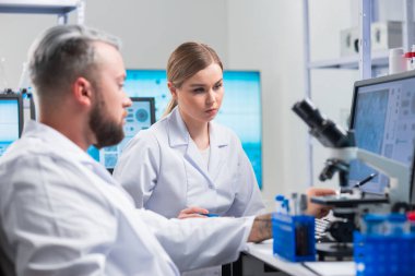 Profesyonel bilim adamları modern bir bilimsel araştırma laboratuvarında bir aşı üzerinde çalışıyorlar. Genetik mühendisliği işyeri. Gelecekteki teknoloji ve bilim.