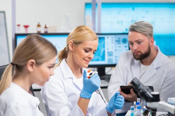 A equipe profissional de cientistas está trabalhando em uma vacina em um moderno laboratório de pesquisa científica. Engenheiro genético no trabalho. Tecnologia e ciência futuras. — Fotografia de Stock