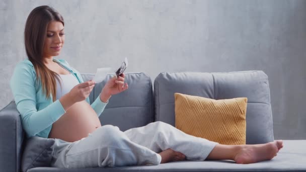 Ung gravid kvinna vilar hemma och väntar barn. Begreppet graviditet, moderskap, hälsa och livsstil. — Stockvideo