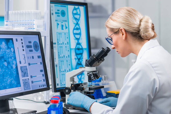Professional female scientist is working on a vaccine in a modern scientific research laboratory. Genetic engineer workplace. Future technology and science.
