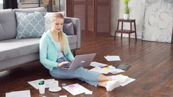 Mujer joven tiene video llamada reunión conferencia mientras está sentado en el suelo en casa. Estudiante, empresaria o freelancer que trabaja o estudia a distancia. Concepto de aprendizaje a distancia y empleo. — Vídeos de Stock