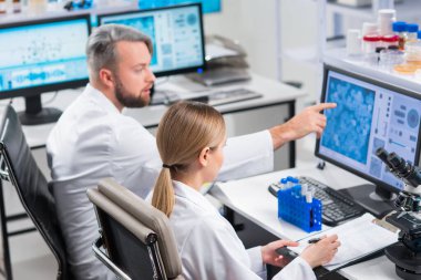 Profesyonel bilim adamları modern bir bilimsel araştırma laboratuvarında bir aşı üzerinde çalışıyorlar. Genetik mühendisliği işyeri. Gelecekteki teknoloji ve bilim.