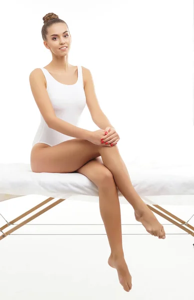 Junge, fitte und schöne brünette Frau im weißen Badeanzug posiert vor weißem Hintergrund. Gesundheit, Ernährung, Sport und Fitness. — Stockfoto