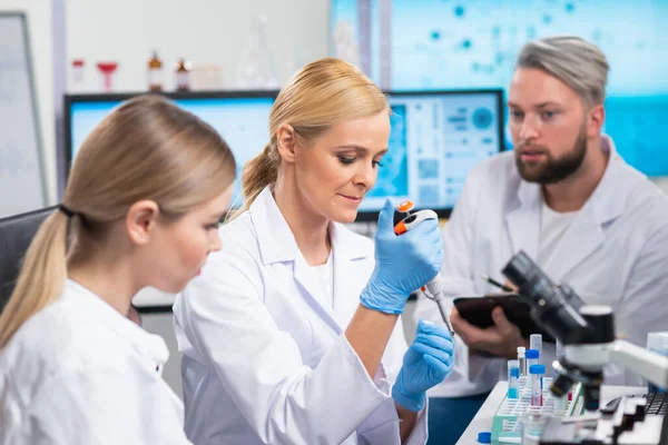 Professionella forskarlag arbetar med ett vaccin i ett modernt vetenskapligt forskningslaboratorium. Genetisk ingenjör på arbetsplatsen. Framtida teknik och vetenskap. — Stockfoto