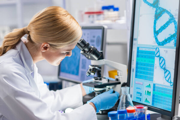 Professional female scientist is working on a vaccine in a modern scientific research laboratory. Genetic engineer workplace. Future technology and science.