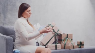 Genç hamile kadın evde dinleniyor ve bebek bekliyor. Hamilelik, annelik, sağlık ve yaşam tarzı kavramı.