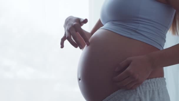 Jonge zwangere vrouw rust thuis en verwacht een baby. Het concept zwangerschap, moederschap, gezondheid en levensstijl. — Stockvideo