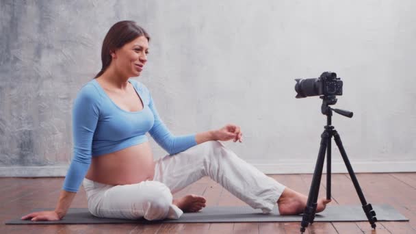 Uma jovem grávida faz um vlog sobre a gravidez. O influenciador grava vídeos ou fluxos em uma câmera. — Vídeo de Stock