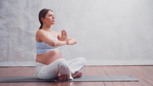 Ung gravid kvinna som gör yogaövningar och mediterar hemma. Begreppet hälsa, mindfulness, avkoppling och välbefinnande. — Stockvideo