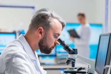 Profesyonel bilim adamları modern bir bilimsel araştırma laboratuvarında bir aşı üzerinde çalışıyorlar. Genetik mühendisliği işyeri. Gelecekteki teknoloji ve bilim.
