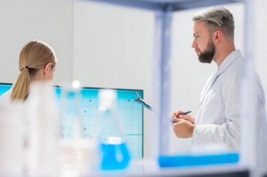 Profesyonel bilim adamları modern bir bilimsel araştırma laboratuvarında bir aşı üzerinde çalışıyorlar. Genetik mühendisliği işyeri. Gelecekteki teknoloji ve bilim.