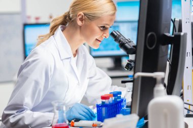Profesyonel kadın bilim adamı modern bir bilimsel araştırma laboratuvarında aşı üzerinde çalışıyor. Genetik mühendisliği işyeri. Gelecekteki teknoloji ve bilim.