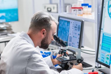 Profesyonel bilim adamı modern bir bilimsel araştırma laboratuvarında aşı üzerinde çalışıyor. Genetik mühendisliği işyeri. Gelecekteki teknoloji ve bilim.