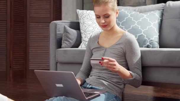 若い女性は、ラップトップとクレジットカードを使用してオンラインで商品を注文します。オンラインショッピング、配達および支払システムの概念. — ストック動画