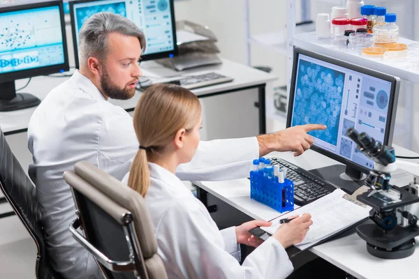 Professioneel team van wetenschappers werkt aan een vaccin in een modern wetenschappelijk onderzoekslaboratorium. Genetische ingenieur werkplek. Toekomstige technologie en wetenschap. — Stockfoto