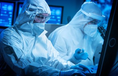 Bilim adamları laboratuvar ekipmanları, mikroskop ve bilgisayar teknolojisi kullanarak modern bir bilim laboratuvarında çalışıyorlar. Yeni aşıların icadı. Bilim ve Sağlık kavramı.